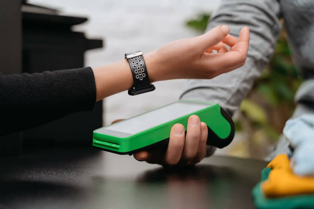 woman holds wristband over scanner