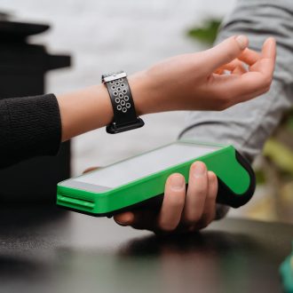 woman holds wristband over scanner