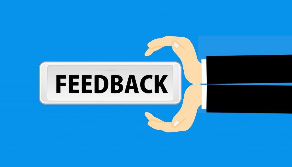 illustration of hands holding a sign that says feedback
